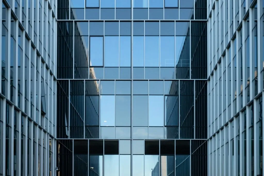 Contemporary glass office building facade reflecting urban architecture