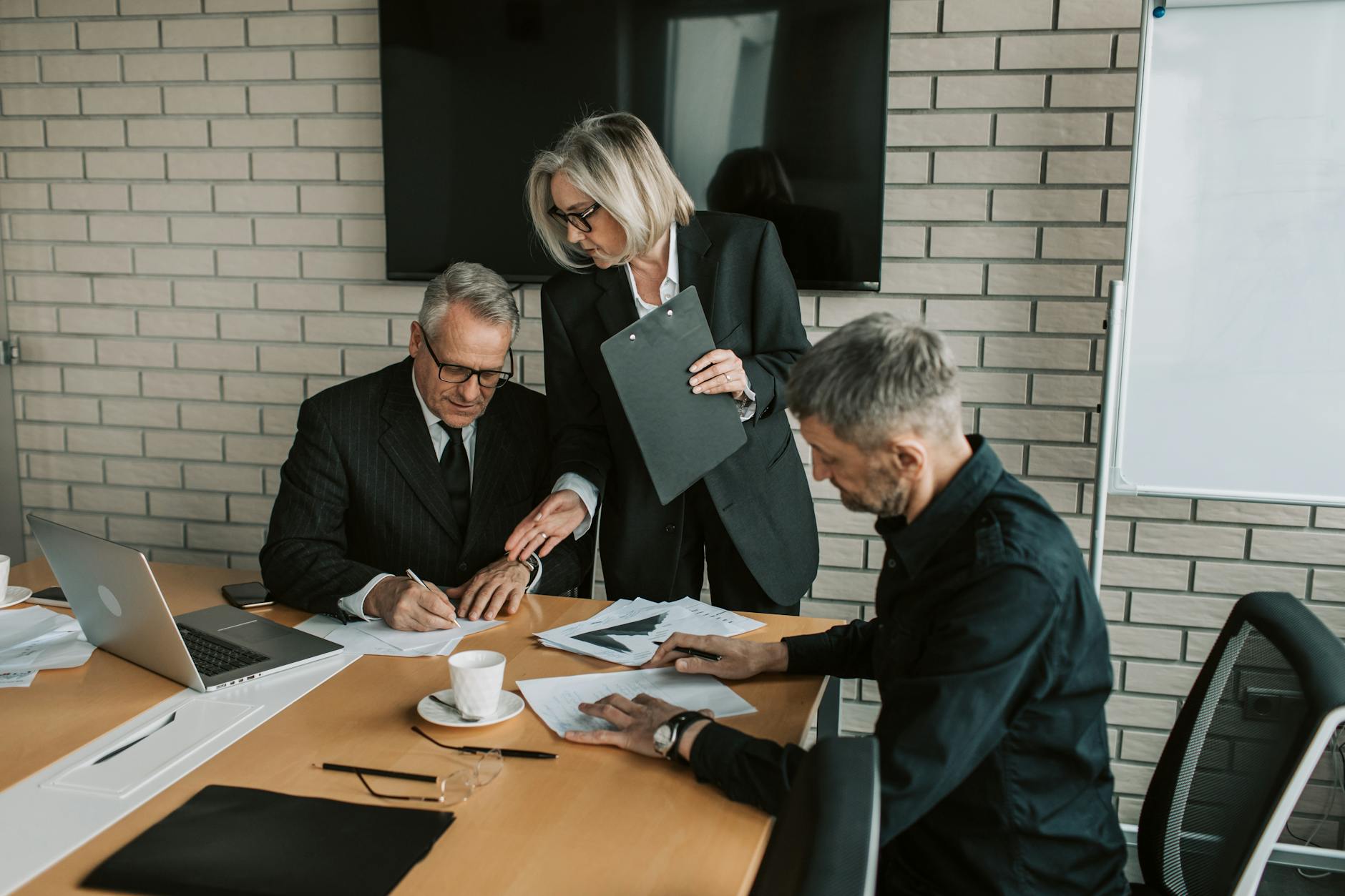 Business professionals reviewing and signing documents for a private investment fund